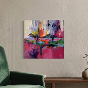 May include: An abstract painting with a textured surface. The artwork features bold brushstrokes in shades of pink, purple, green, yellow, and blue. The painting is mounted on a square canvas and hangs on a neutral-colored wall.