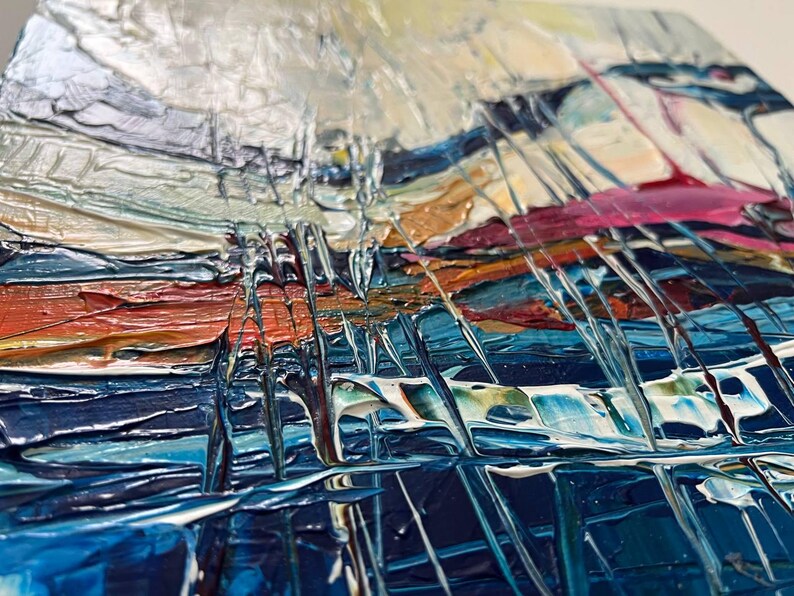 May include: Abstract painting with thick brushstrokes in shades of blue, orange, white, and pink. The textured surface creates a sense of depth and movement. The artwork appears to be an original piece, showcasing a modern art style.