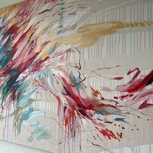 May include: Abstract canvas art featuring a dynamic composition of brushstrokes in shades of red, pink, teal, and gold. The artwork has a neutral background with vertical lines and drips, creating a sense of movement and depth. A modern piece for home decor.