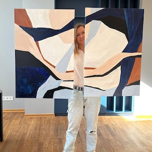 May include: Abstract art piece with a geometric design. The artwork features shapes in shades of navy blue, brown, black, and beige. The painting is displayed in two panels, creating a modern aesthetic.