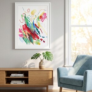 May include: A framed abstract art print featuring vibrant watercolor brushstrokes in red, green, blue, and yellow on a white background. The artwork displays dynamic, gestural marks, including circles, dashes, and layered color patches.