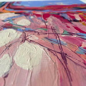 May include: Abstract painting with thick brushstrokes in shades of pink, white, blue, and red. The artwork features a textured surface with visible paint layers, creating a dynamic and expressive composition. The painting evokes a sense of movement and depth.