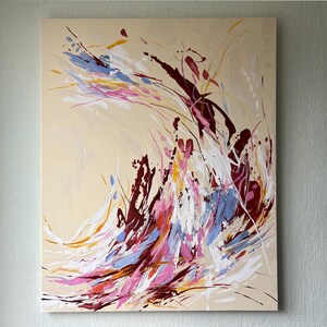 May include: Abstract painting on canvas with a beige background. The artwork features dynamic brushstrokes in shades of burgundy, white, blue, pink, and yellow. The composition is a vibrant display of color and movement, suitable for home decor.