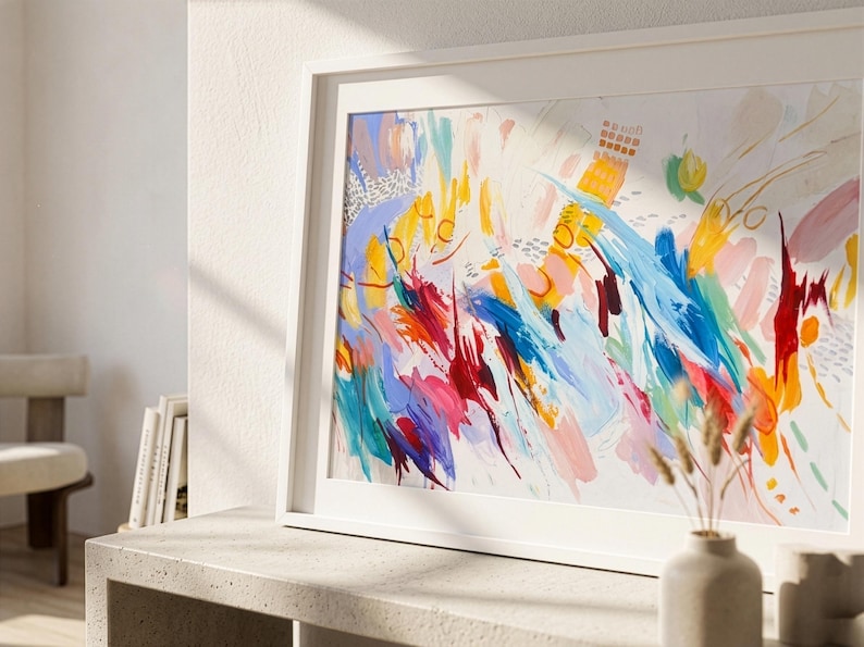May include: A framed horizontal wall art print featuring an abstract composition with vibrant, expressive brushstrokes in shades of bright blue, sunny yellow, deep red, and soft pink, set against a clean white background with scattered textured marks.