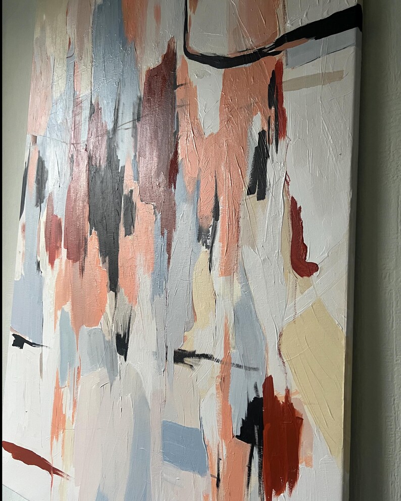 May include: A rectangular canvas painting featuring vertical abstract brushstrokes in shades of peach, light blue, cream, dark red, and black. The textured paint application creates a layered effect across the white background surface.