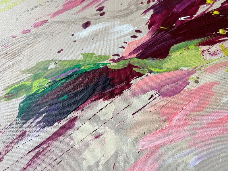 May include: Abstract painting with a palette of pink, green, purple, and white brushstrokes. The artwork features a textured canvas with dynamic, diagonal strokes and splatters, creating a sense of movement and depth. The colors blend and overlap.