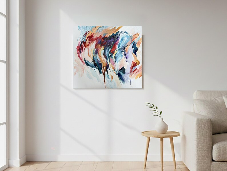 May include: Abstract painting on canvas featuring a profile in shades of red, blue, and orange. The artwork is displayed on a white wall, adding a pop of color to the room. The painting's brushstrokes create a dynamic and expressive composition.