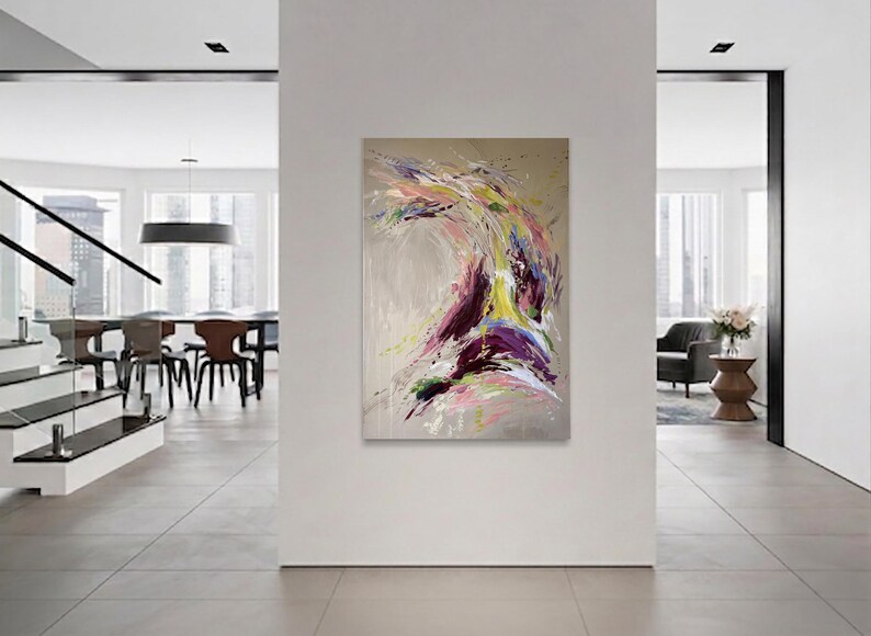 May include: Abstract painting with a dynamic composition of swirling brushstrokes. The artwork features a palette of purple, yellow, pink, and green against a neutral background. The painting is displayed in a modern, minimalist interior.