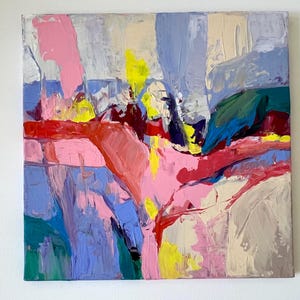 May include: Abstract artwork with bold brushstrokes in pink, red, blue, yellow, green, and beige. The painting has a textured surface with visible layers of paint, creating a dynamic composition. The artwork is on a square canvas.