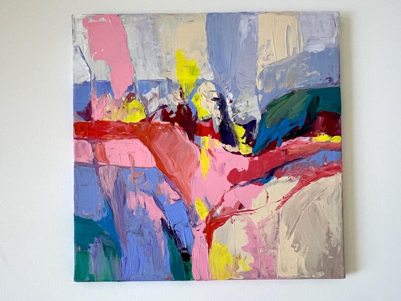 May include: Abstract artwork with bold brushstrokes in pink, red, blue, yellow, green, and beige. The painting has a textured surface with visible layers of paint, creating a dynamic composition. The artwork is on a square canvas.