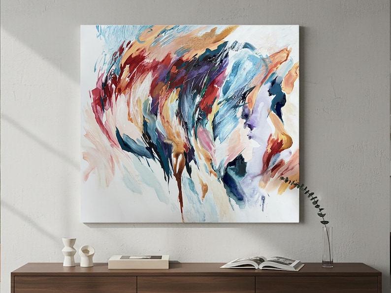 May include: Abstract art painting with a vibrant display of colors. The artwork features brushstrokes in shades of red, blue, orange, and purple, creating a dynamic and expressive composition. The painting is displayed on a white canvas.