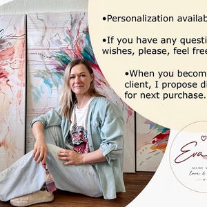 May include: An artist sits in front of three abstract paintings with red, blue, and green brushstrokes. The artist wears a light blue jacket, white t-shirt, and jeans. Text on the image says "Personalization available" and "Made with love & care."