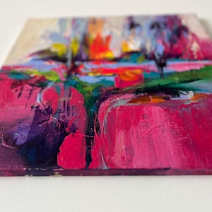 May include: Abstract painting with thick brushstrokes in shades of pink, purple, green, and blue. The artwork features a textured surface and a vibrant color palette, creating a dynamic and expressive composition. The painting is on a square canvas.