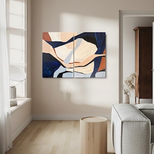 May include: Abstract art piece composed of two panels. The artwork features a blend of colors, including navy blue, beige, and rust. The design showcases organic shapes and forms, creating a modern and artistic aesthetic. The artwork is displayed in a living room setting.