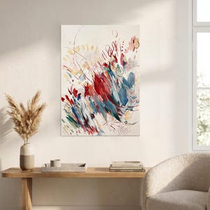 May include: A rectangular canvas painting featuring an abstract composition with energetic brushstrokes in shades of deep red, navy blue, and soft yellow against a cream-colored background, displaying layered textures and dynamic, sweeping lines.