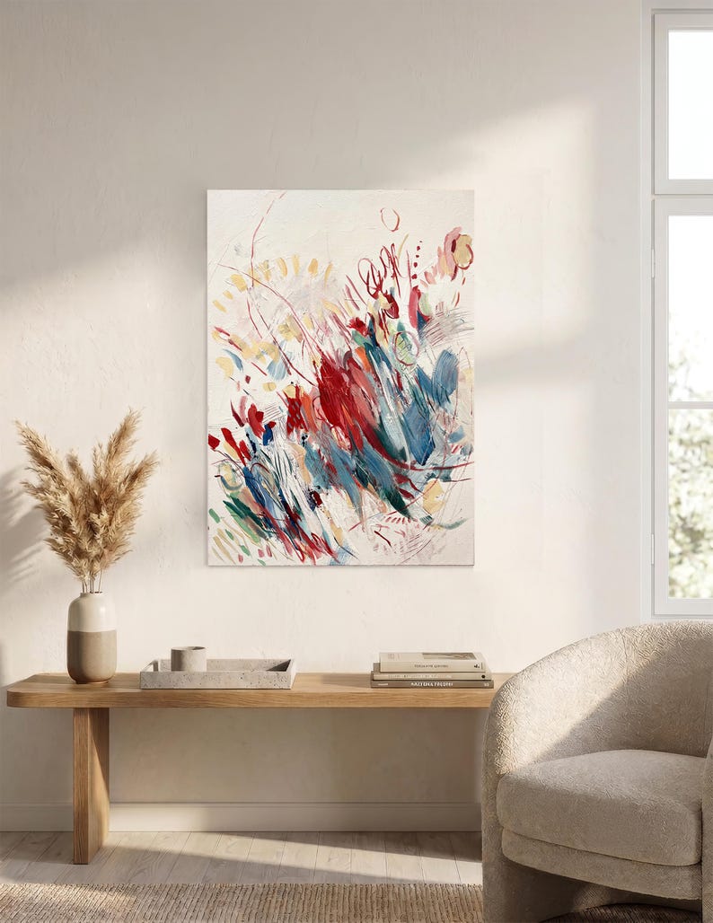 May include: A rectangular canvas painting featuring an abstract composition with energetic brushstrokes in shades of deep red, navy blue, and soft yellow against a cream-colored background, displaying layered textures and dynamic, sweeping lines.