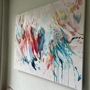 Pode incluir: Uma pintura retangular em tela com uma composi&ccedil;&atilde;o abstrata de pinceladas energ&eacute;ticas em tons de azul-petr&oacute;leo, rosa brilhante, vermelho profundo e amarelo sobre fundo branco, acentuada por pequenos pontos, c&iacute;rculos e gotas de tinta.