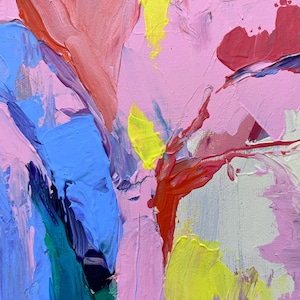 May include: Abstract oil painting in pink, blue, red, and yellow. The thick brushstrokes create a textured surface. The artwork has a dynamic composition with bold colour contrasts and expressive marks.