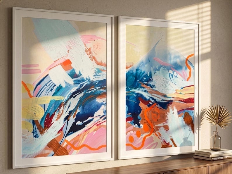 Puede incluir: Dos l&aacute;minas de arte mural rectangulares enmarcadas con pinceladas abstractas en tonos azul, rosa, naranja y blanco. La obra muestra texturas de pintura superpuestas con l&iacute;neas audaces y formas org&aacute;nicas, dentro de marcos blancos delgados.