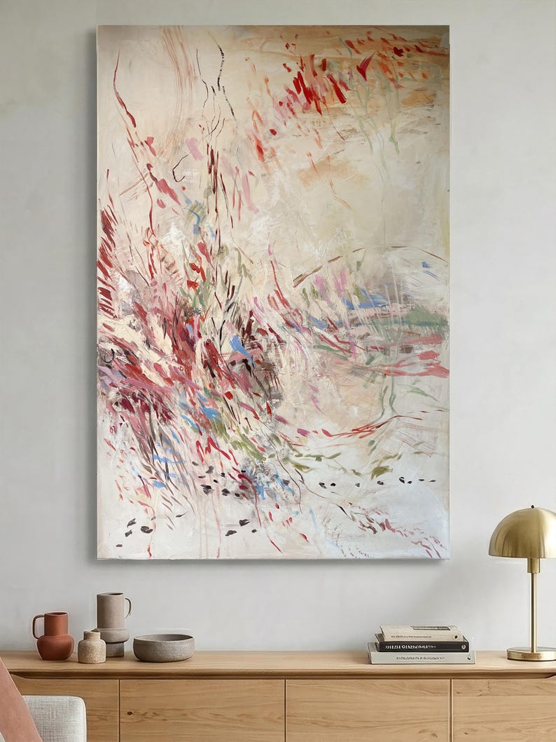 May include: A large rectangular canvas painting featuring an abstract composition with a cream-colored background. The artwork displays dynamic, sweeping brushstrokes in shades of deep red, burgundy, soft pink, sage green, and touches of bright blue.