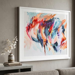 K&ouml;nnte beinhalten: Ein quadratisches gerahmtes Wandbild mit einem abstrakten Gem&auml;lde, das ausdrucksstarke, schwungvolle Pinselstriche in leuchtenden Rot-, Orange-, Dunkelblau-, Violett- und zarten Rosat&ouml;nen auf wei&szlig;em Grund in einem schlichten wei&szlig;en Rahmen zeigt.