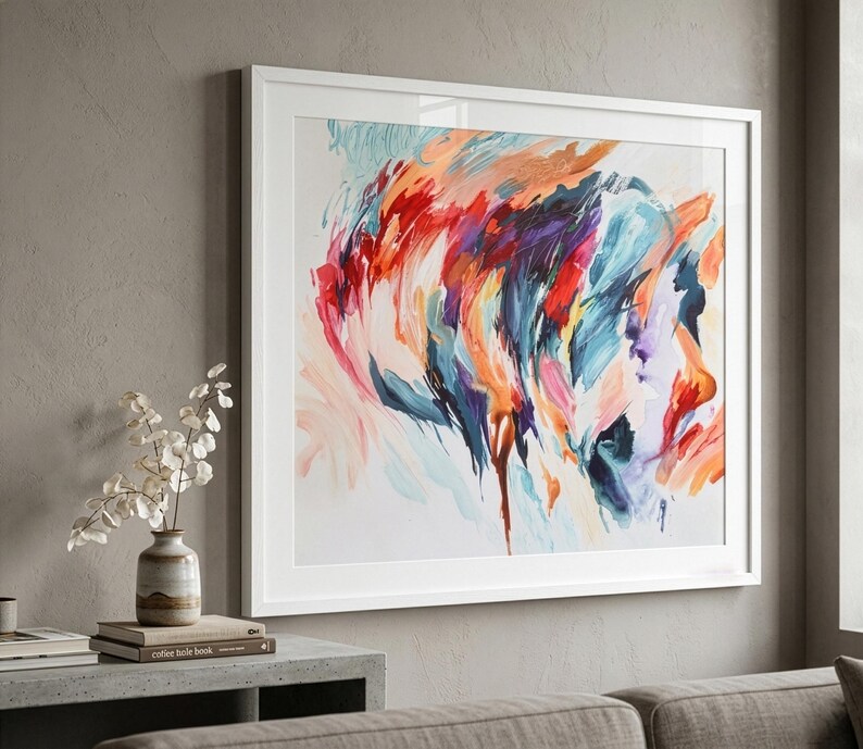 K&ouml;nnte beinhalten: Ein quadratisches gerahmtes Wandbild mit einem abstrakten Gem&auml;lde, das ausdrucksstarke, schwungvolle Pinselstriche in leuchtenden Rot-, Orange-, Dunkelblau-, Violett- und zarten Rosat&ouml;nen auf wei&szlig;em Grund in einem schlichten wei&szlig;en Rahmen zeigt.