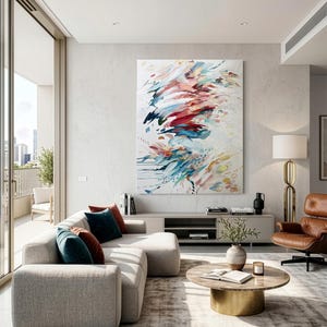 Pode incluir: Uma grande pintura retangular em tela com pinceladas abstratas em tons de vermelho, azul, azul-petr&oacute;leo e dourado sobre um fundo branco, exibida numa parede clara acima de um m&oacute;vel baixo numa sala de estar.