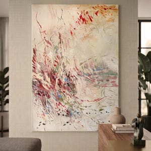 May include: A large rectangular canvas painting featuring an abstract composition with a cream-colored background. The artwork displays energetic, gestural brushstrokes in shades of deep red, burgundy, soft pink, muted green, and blue.