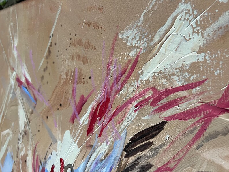May include: Abstract painting with a tan background and bold brushstrokes in white, red, and black. The artwork features a textured surface with visible paint layers and splatters, creating a dynamic and expressive composition.