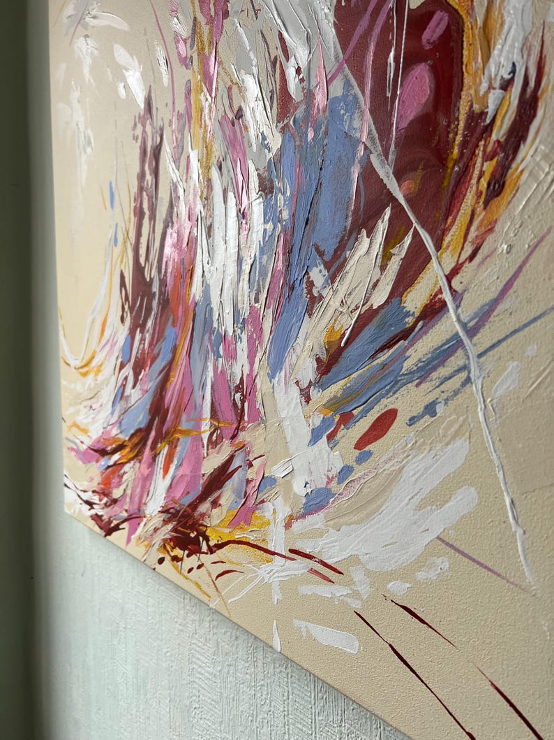 May include: Abstract painting with a beige background and bold brushstrokes in shades of red, pink, blue, white, and yellow. The artwork features a textured surface with visible paint layers, creating a dynamic and expressive composition.