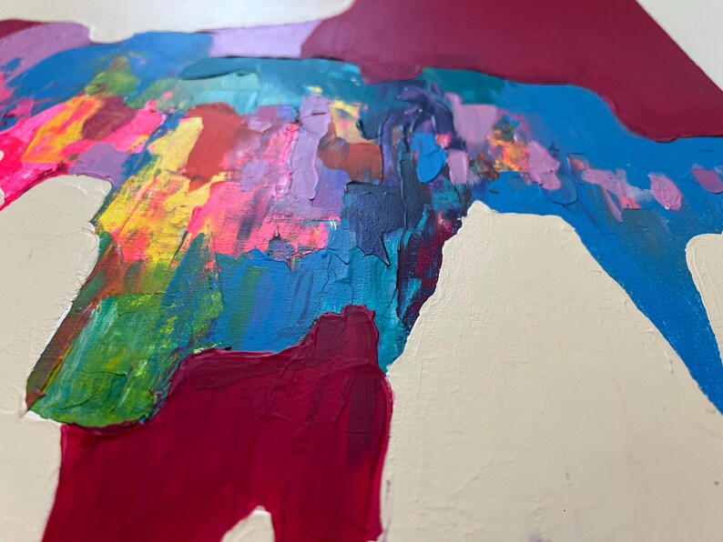 May include: Abstract artwork with bold brushstrokes in a variety of colours. The painting showcases pink, yellow, green, blue, and purple shades, with deep red accents set against a neutral backdrop. The textured paint creates a dynamic visual effect.
