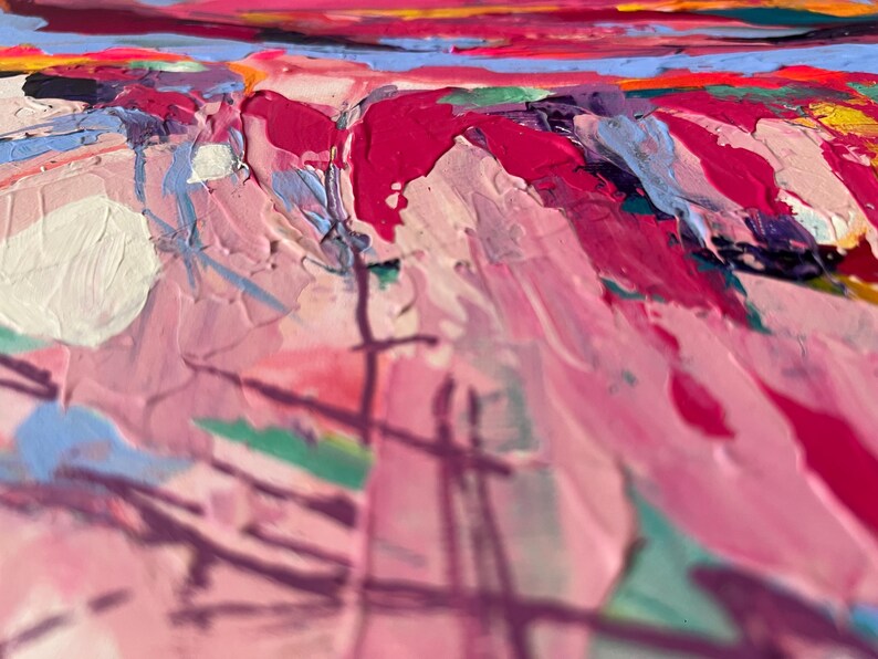 May include: Close-up of an abstract painting with thick brushstrokes. The artwork features a palette of pinks, reds, blues, and yellows. The texture is heavily layered, creating a sense of depth and movement. The style is impressionistic.