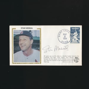 May include: Envelope featuring a photograph of Stan Musial, a baseball player, with his signature. The envelope includes a Saint Louis postmark dated May 2, 1984, and a Babe Ruth stamp. Text on the envelope commemorates a baseball achievement.