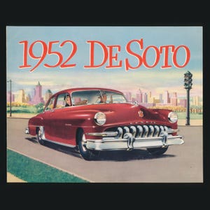 May include: Illustration of a 1952 De Soto car in a maroon color, driving on a road with a city skyline in the background. The text "1952 De Soto" is displayed at the top of the image.