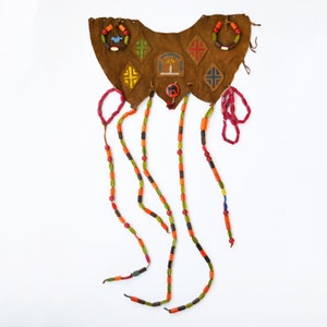 May include: A brown leather bib-style necklace with colorful beaded strands and decorative accents. The necklace features painted geometric designs and small beaded rings. The beaded strands are in shades of orange, green, red, and brown.