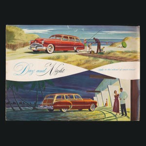 May include: A white ceramic mug with a black handle and the text "But First, Coffee" in a bold, black font. The mug is set against a blurred background, suggesting a cozy setting.