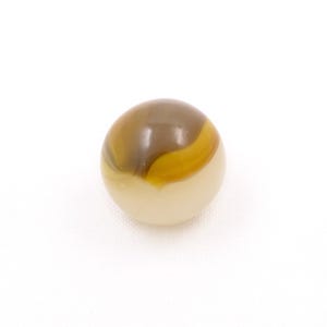 May include: A single, round marble with a cream-colored base and a swirling pattern of brown and yellow. The marble is set against a plain white background, highlighting its colors and design.