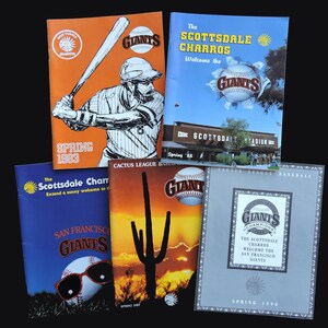 May include: Five vintage baseball programs featuring the San Francisco Giants and Scottsdale Charros. The covers display various graphics including a batter, Scottsdale Stadium, a cactus silhouette, and baseballs with text like Spring 1983 and 1990.