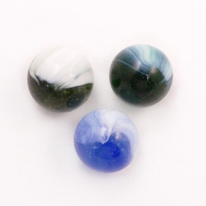 May include: Three glass marbles with swirling patterns. One marble is white and green, another is blue and white, and the third is dark green and blue. The marbles are on a white background.