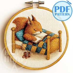 May include: Embroidered hoop art featuring a sleeping squirrel in a bed, reading a book. The squirrel is brown with a blue and gold blanket. The hoop has a gold finish, and the text "PDF PATTERN" is visible.