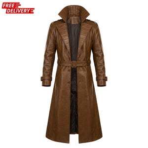 May include: A long brown leather trench coat featuring a wide collar, a belted waist with a rectangular buckle, and button closures. The coat has long sleeves with buckled straps at the cuffs, shoulder epaulets, and a dark brown interior lining.