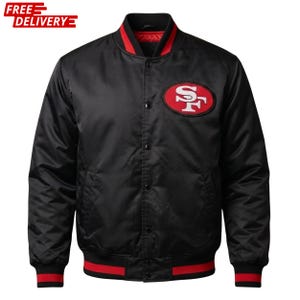 May include: Black satin bomber jacket with red accents on the collar, cuffs, and hem. Features a red and white team logo patch on the chest. The jacket has a button-up front.