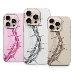 Könnte beinhalten: Drei Handyhüllen mit einem Dornenzweig-Design. Die Hüllen sind in Rosa, Weiß und Beige gehalten, jede mit einem anderen Farbschema für den dornigen Zweig. Die Hüllen haben einen transparenten Rand und einen Kameraausschnitt.