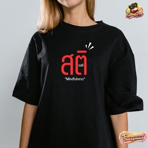 May include: Black t-shirt with a red graphic that includes Thai script and the English word "sati" and the phrase "Mindfulness". The shirt has short sleeves and a relaxed fit.