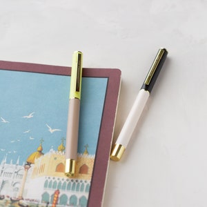 Bolígrafos de tinta negra con detalles dorados y bloques de color verde y gris topo • Juego de 2