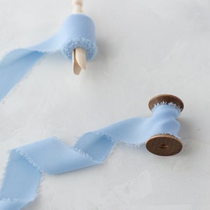 Fita de chiffon de seda sintética com bordas desfiadas azul suave • 1,5" • 5 jardas em pino de madeira