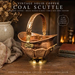 May include: Vintage copper coal scuttle with a brass handle and base. The hammered copper scuttle, circa mid-20th century, is labeled as 2 lbs of solid copper and brass. The text reads "Perfect for hearth, cottage, or traditional decor."