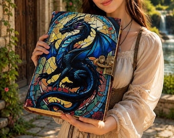 May include: A rectangular hardcover book featuring a vibrant stained-glass style illustration of a blue and black dragon. The cover is secured with a metallic bronze-colored latch and displays intricate geometric patterns in yellow and red.