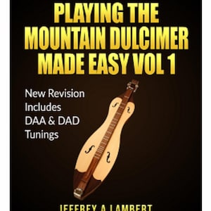 Puede incluir: Portada del libro "PLAYING THE MOUNTAIN DULCIMER MADE EASY VOL 1" con una ilustración de dulcimer. La portada incluye texto sobre nuevas revisiones y afinaciones, con el nombre del autor, Jeffrey A. Lambert. El fondo es oscuro.