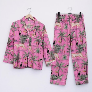 Puede incluir: Conjunto de pijama rosa con estampado de jungla con tucanes, cebras, leopardos y palmeras. La camisa de manga larga y el pantal&oacute;n tienen ribetes blancos. El conjunto est&aacute; hecho de una tela suave y ligera.